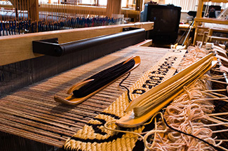 a custom saddleblanket with the owner's name woven into it is in progress on one of Christina Bergh Woolleys computer controlled Jacquard looms